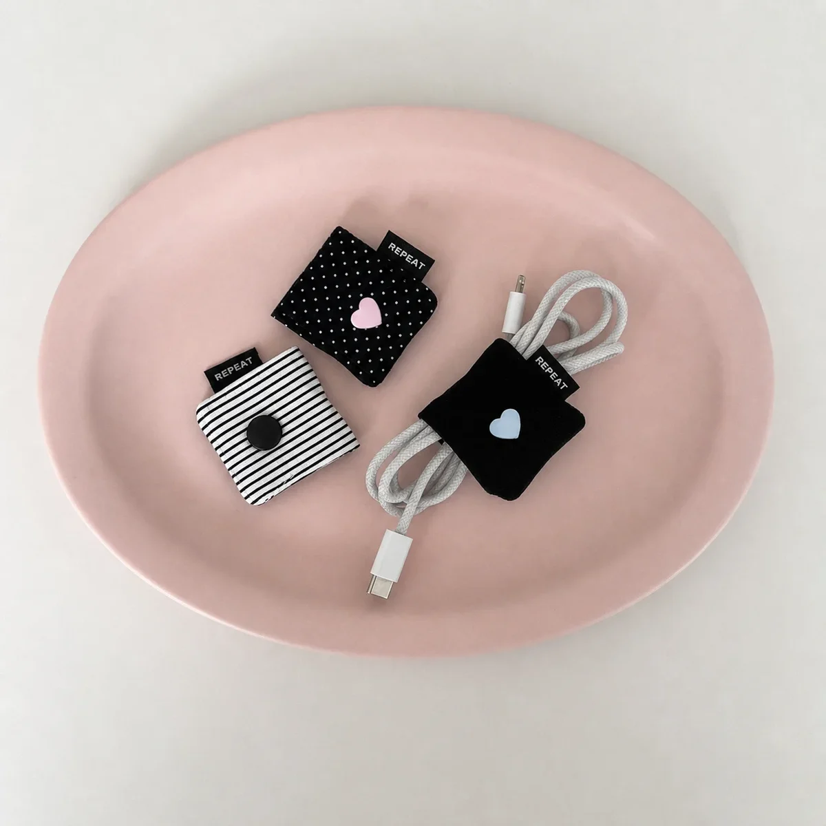 Fabric cable winder for earphones and charging leads, snap closure — representative supplier photograph