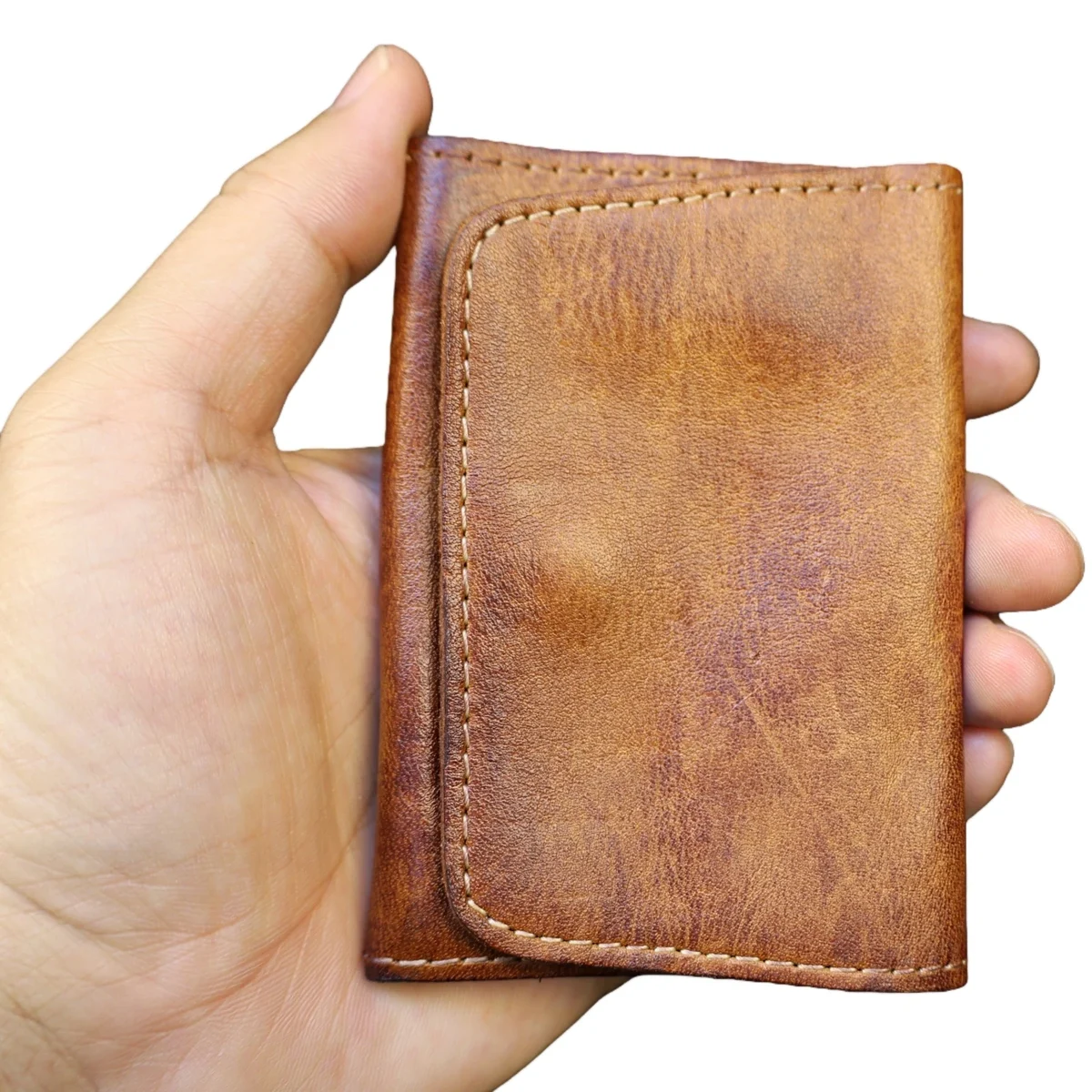 Small vintage-finish cowhide wallet with snap closure, brown — representative supplier photograph