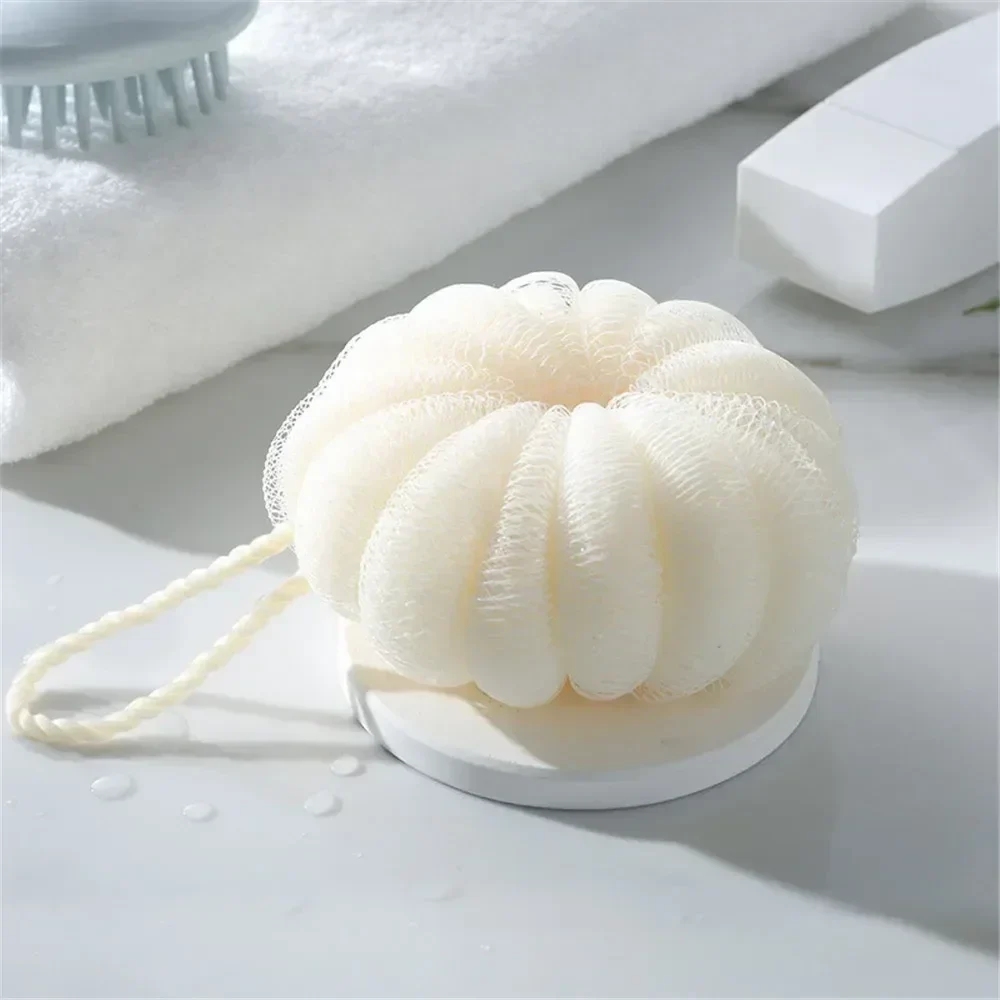 Pumpkin-shaped mesh bath puff with hanging loop, 10 cm — representative supplier photograph
